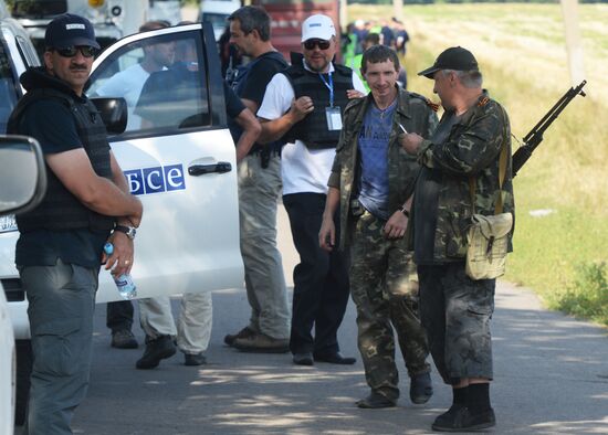 Experts and OSCE representatives work at MH17 crash site