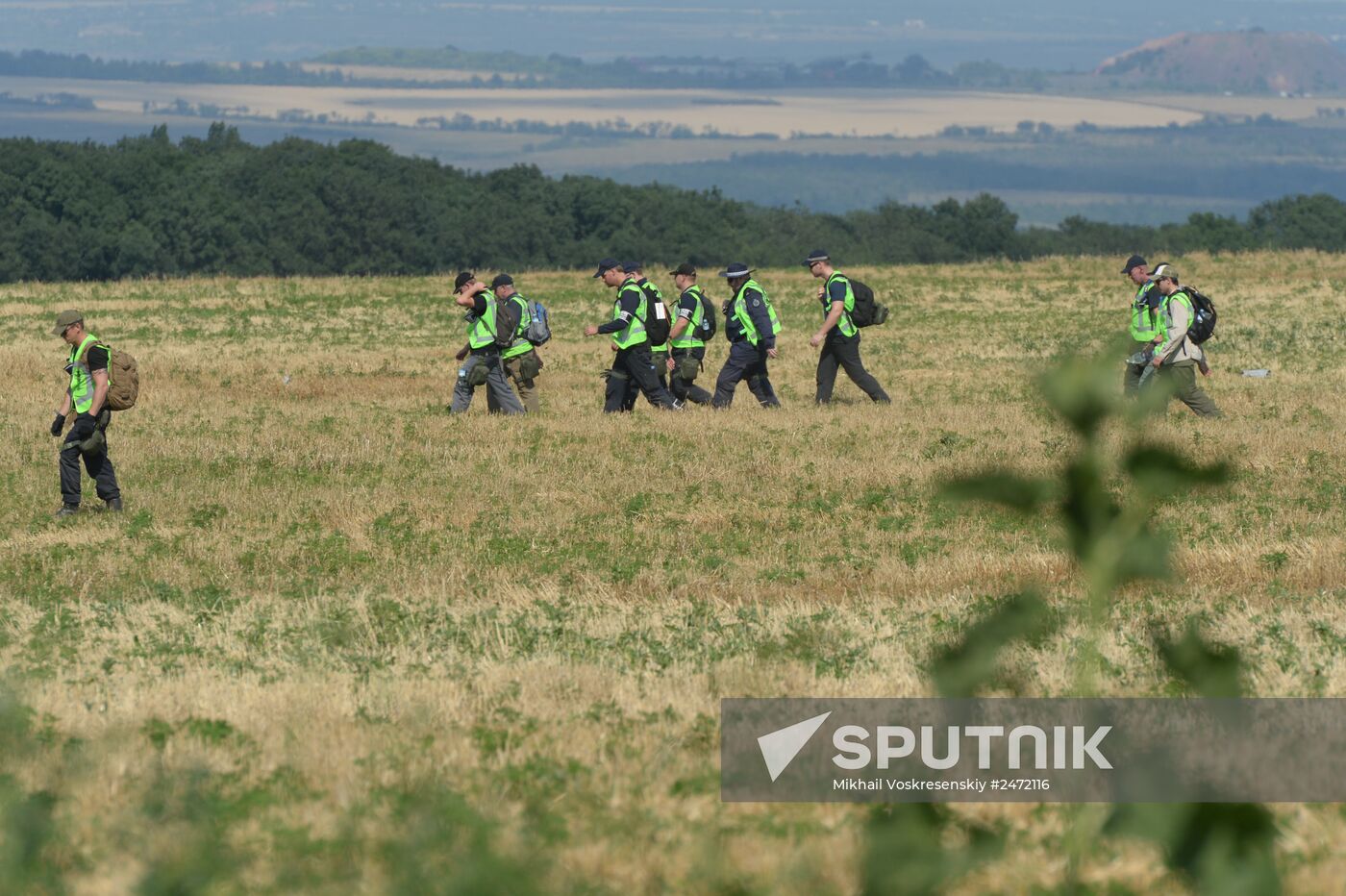 Experts and OSCE representatives work at Boeing crash site