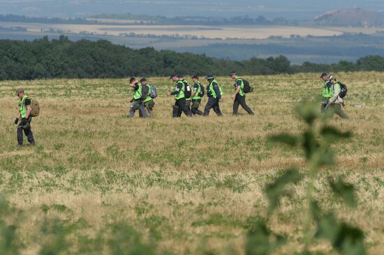 Experts and OSCE representatives work at Boeing crash site
