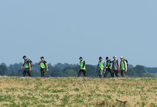 Experts and OSCE representatives work at Boeing crash site
