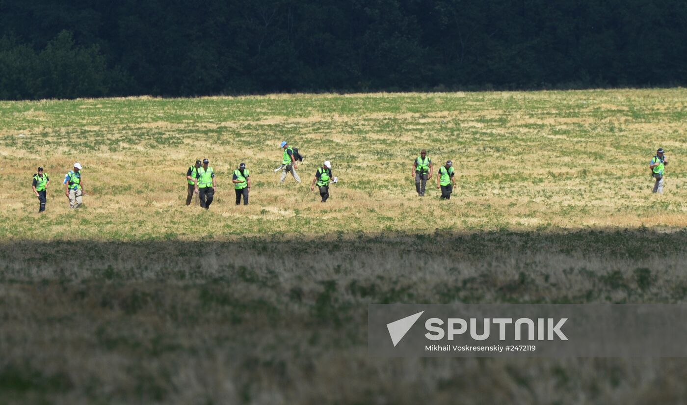 Experts and OSCE representatives work at Boeing crash site