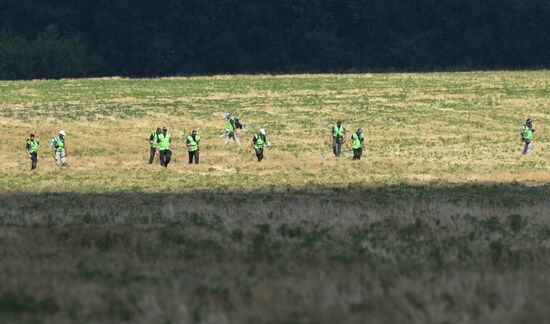 Experts and OSCE representatives work at Boeing crash site