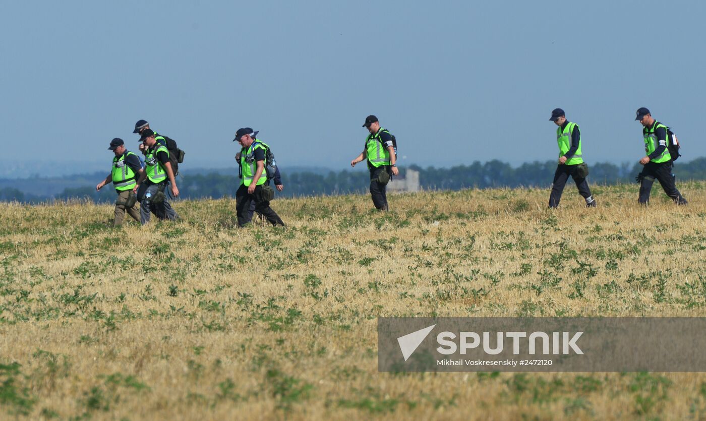 Experts and OSCE representatives work at Boeing crash site
