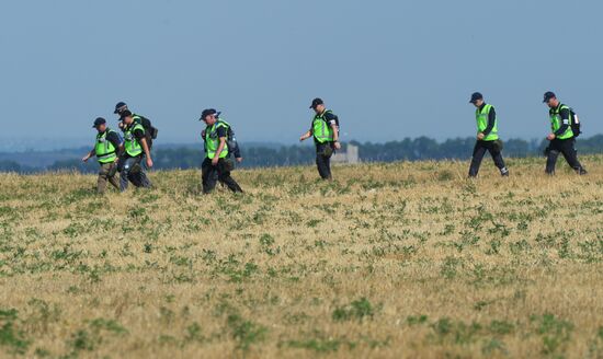 Experts and OSCE representatives work at Boeing crash site