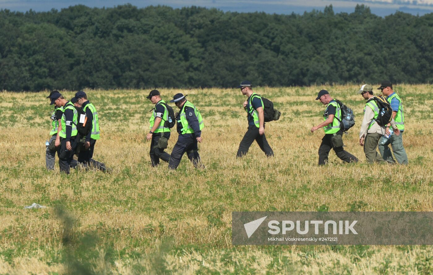 Experts and OSCE representatives work at Boeing crash site