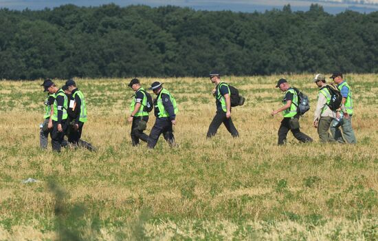 Experts and OSCE representatives work at Boeing crash site