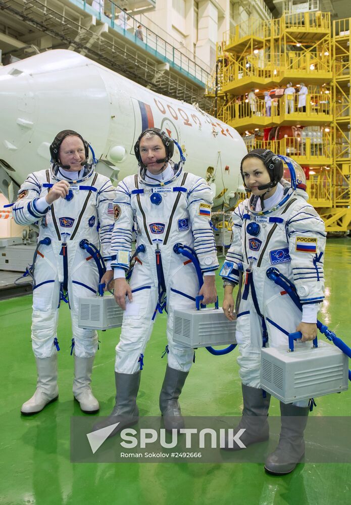 Soyuz TMA-14M crew members inspect spacecraft and try on their space suits