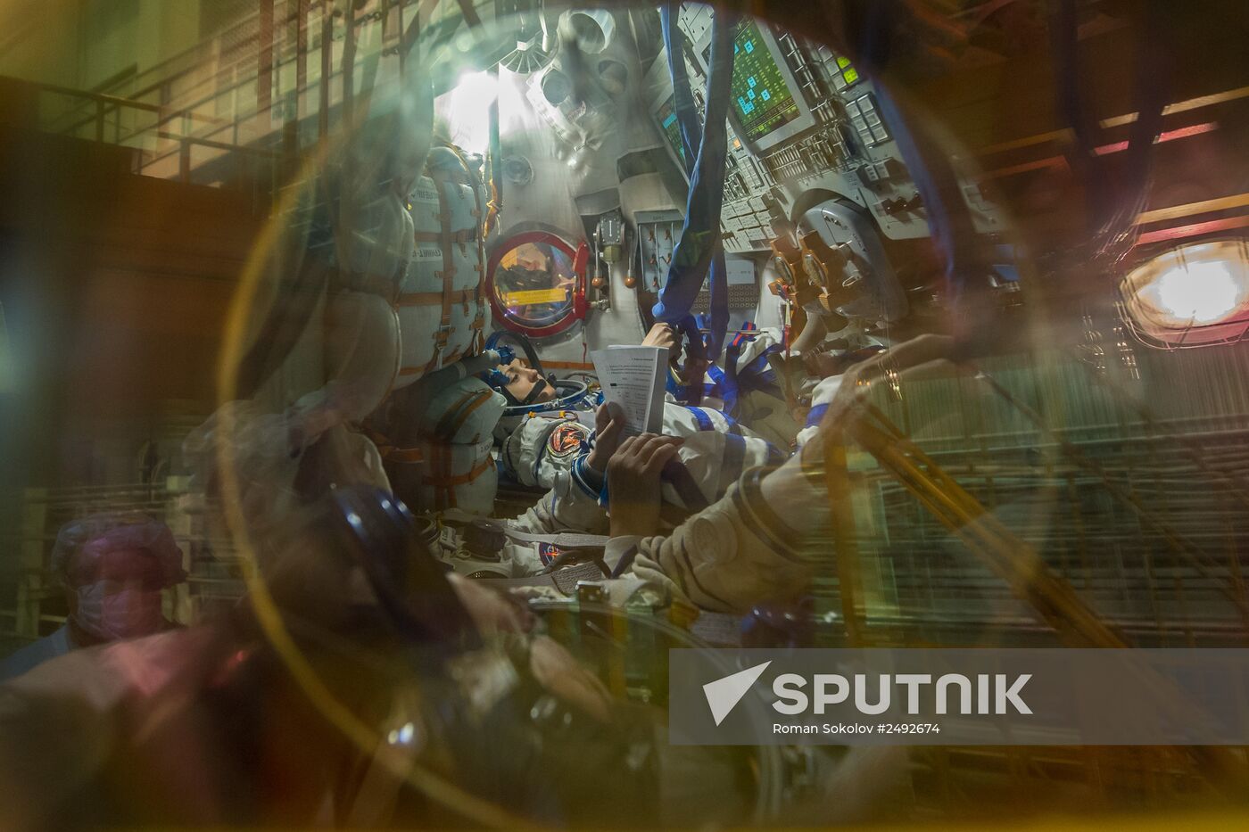 Soyuz TMA-14M crew members inspect spacecraft and try on their space suits