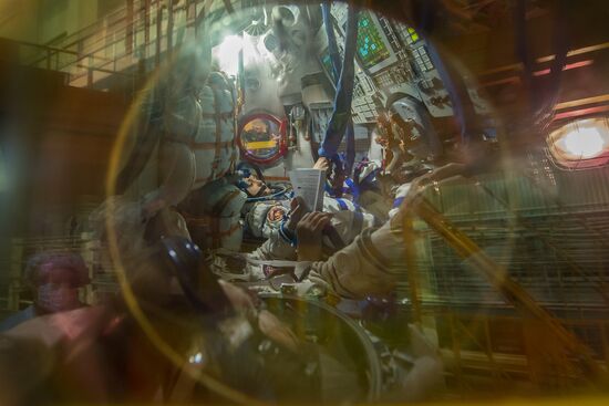 Soyuz TMA-14M crew members inspect spacecraft and try on their space suits