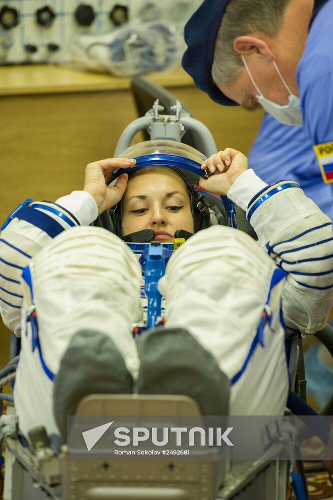 Soyuz TMA-14M crew members inspect spacecraft and try on their space suits