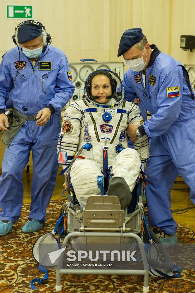 Soyuz TMA-14M crew members inspect spacecraft and try on their space suits