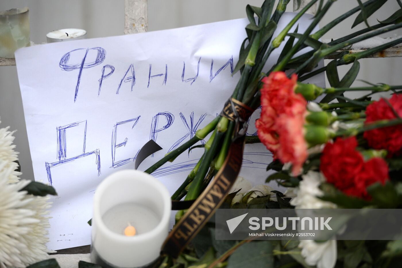 People bring flowers and candles to French embassy in Moscow
