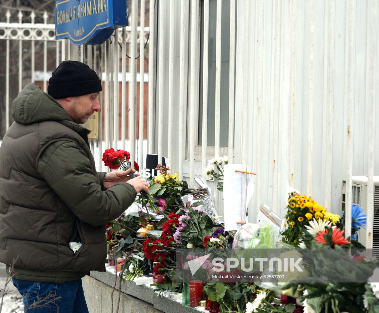 People bring flowers and candles to French embassy in Moscow