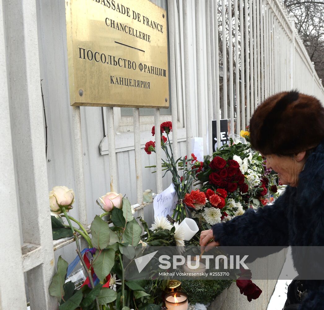 People bring flowers and candles to French embassy in Moscow