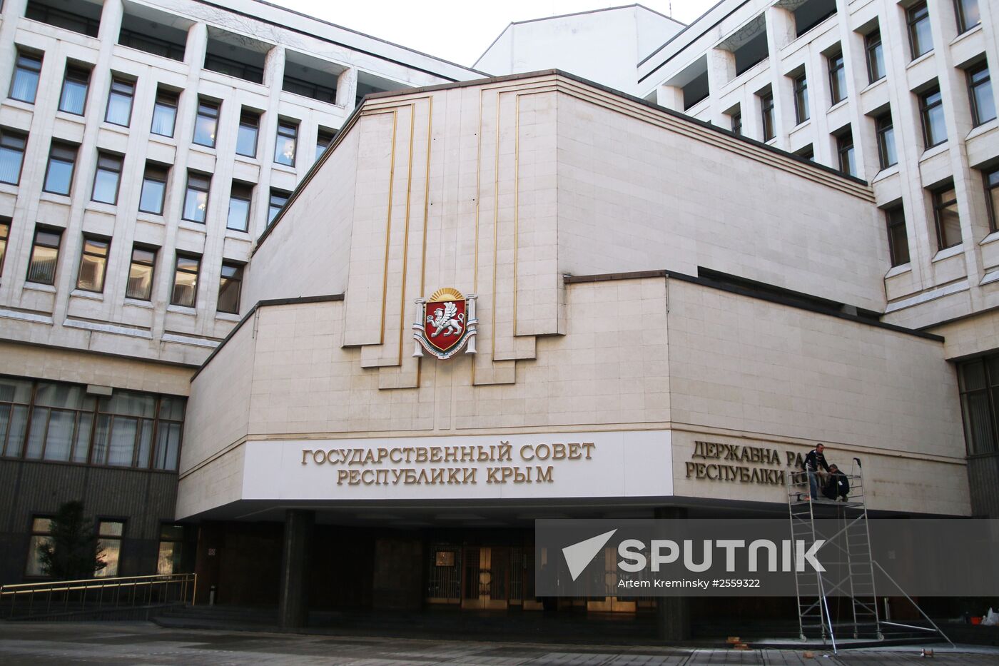 Workers attach Ukrainian sign to facade of State Council of Crimea