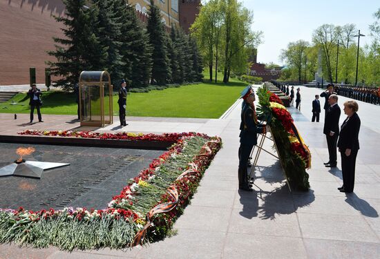 Vladimir Putin and German Chancellor Angela Merkel lay flowers at Tomb of the Unknown Soldier