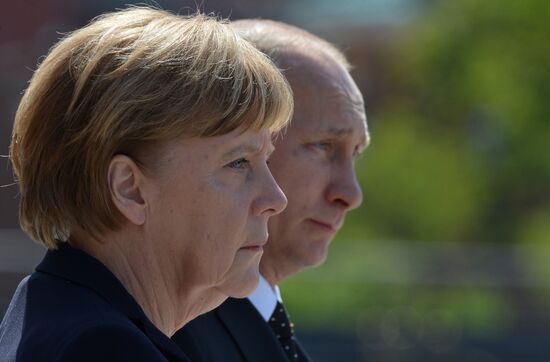 Vladimir Putin and German Chancellor Angela Merkel lay flowers at Tomb of the Unknown Soldier