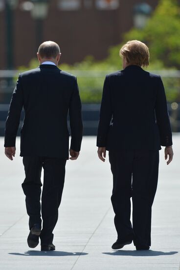 Vladimir Putin and German Chancellor Angela Merkel lay flowers at Tomb of the Unknown Soldier