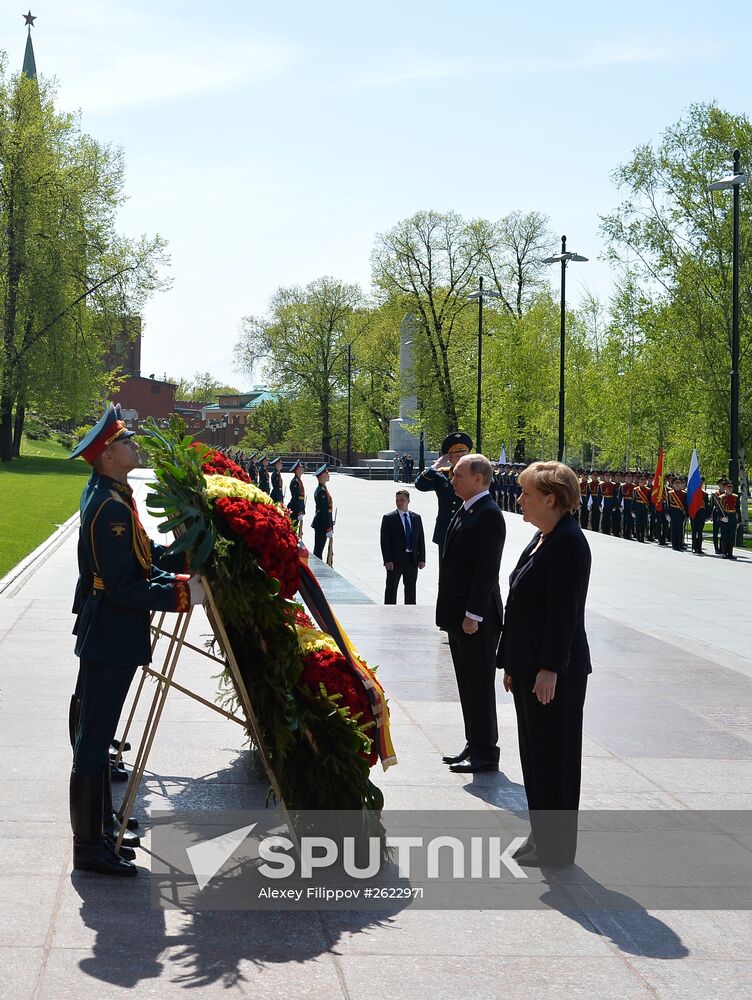 Vladimir Putin and German Chancellor Angela Merkel lay flowers at Tomb of the Unknown Soldier