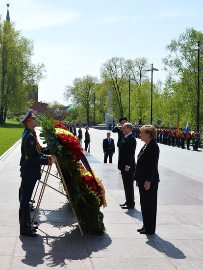 Vladimir Putin and German Chancellor Angela Merkel lay flowers at Tomb of the Unknown Soldier