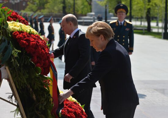 Vladimir Putin and German Chancellor Angela Merkel lay flowers at Tomb of the Unknown Soldier