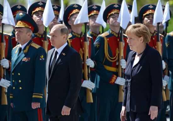 Vladimir Putin and German Chancellor Angela Merkel lay flowers at Tomb of the Unknown Soldier