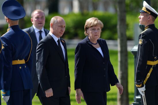 Vladimir Putin and German Chancellor Angela Merkel lay flowers at Tomb of the Unknown Soldier