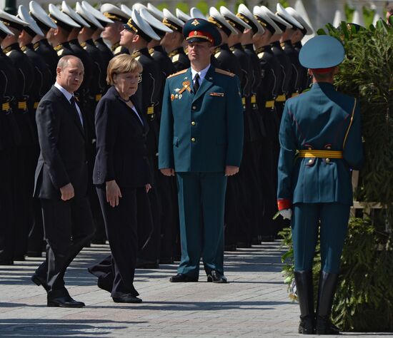 Vladimir Putin and German Chancellor Angela Merkel lay flowers at Tomb of the Unknown Soldier