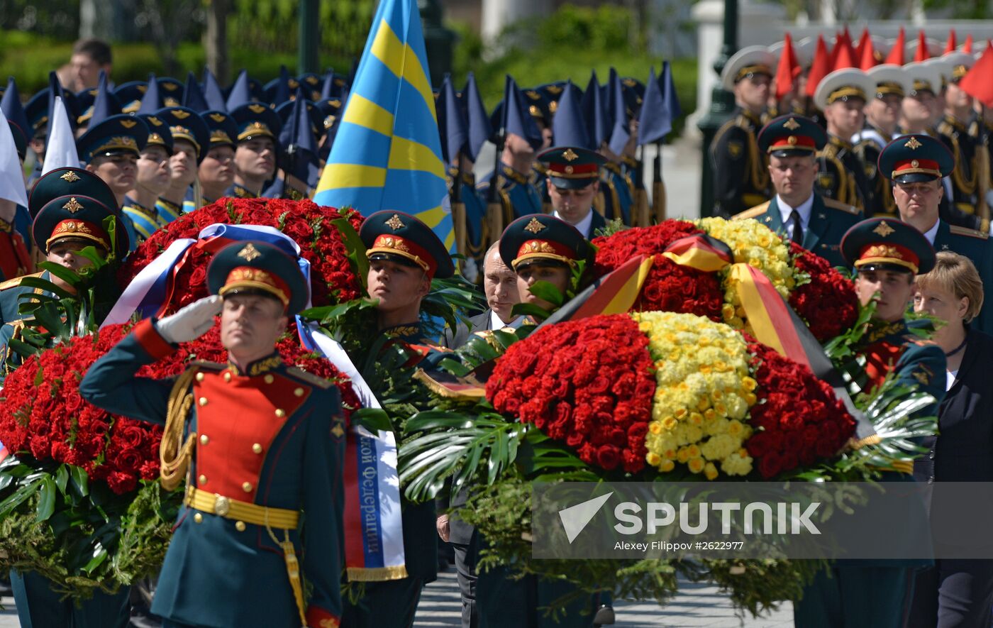Vladimir Putin and German Chancellor Angela Merkel lay flowers at Tomb of the Unknown Soldier