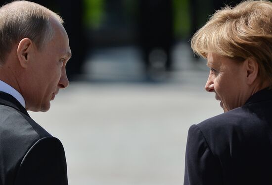 Vladimir Putin and German Chancellor Angela Merkel lay flowers at Tomb of the Unknown Soldier