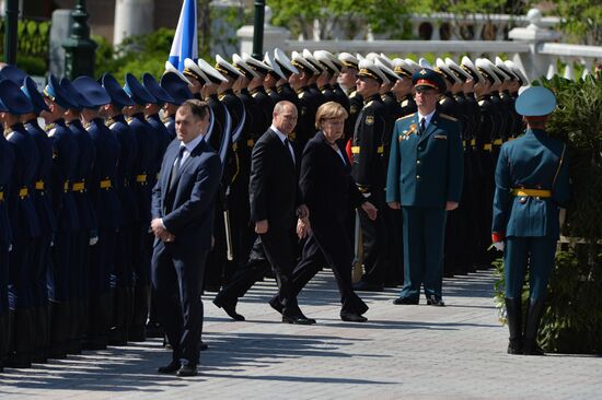 Vladimir Putin and German Chancellor Angela Merkel lay flowers at Tomb of the Unknown Soldier