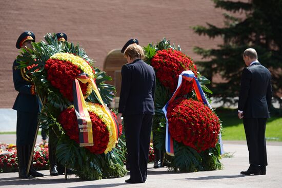 Vladimir Putin and German Chancellor Angela Merkel lay flowers at Tomb of the Unknown Soldier