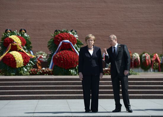 Vladimir Putin and German Chancellor Angela Merkel lay flowers at Tomb of the Unknown Soldier