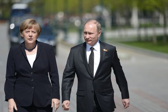 Vladimir Putin and German Chancellor Angela Merkel lay flowers at Tomb of the Unknown Soldier