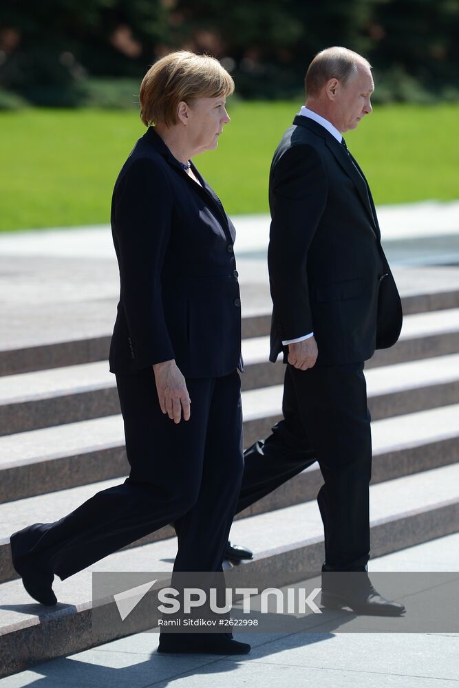 Vladimir Putin and German Chancellor Angela Merkel lay flowers at Tomb of the Unknown Soldier