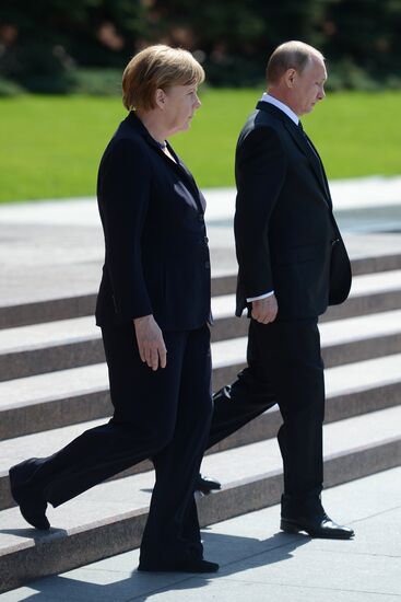 Vladimir Putin and German Chancellor Angela Merkel lay flowers at Tomb of the Unknown Soldier