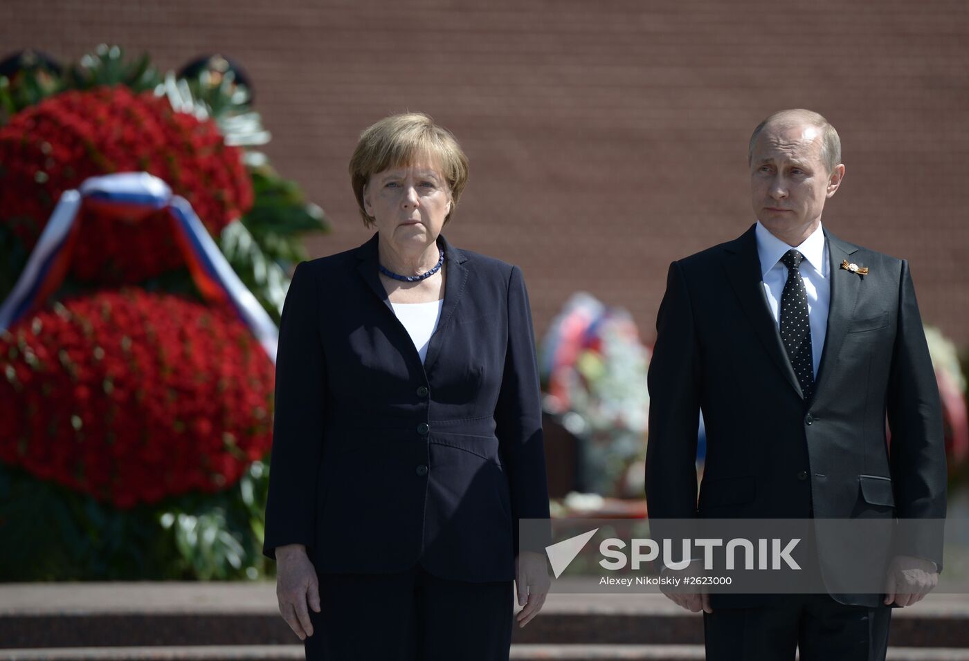 Vladimir Putin and German Chancellor Angela Merkel lay flowers at Tomb of the Unknown Soldier