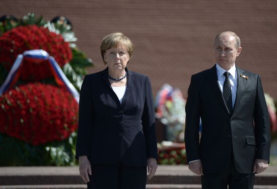 Vladimir Putin and German Chancellor Angela Merkel lay flowers at Tomb of the Unknown Soldier