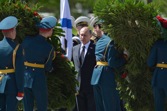 Vladimir Putin and German Chancellor Angela Merkel lay flowers at Tomb of the Unknown Soldier
