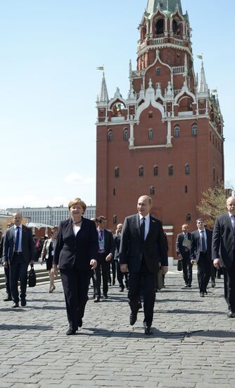 Vladimir Putin and German Chancellor Angela Merkel lay flowers at Tomb of the Unknown Soldier