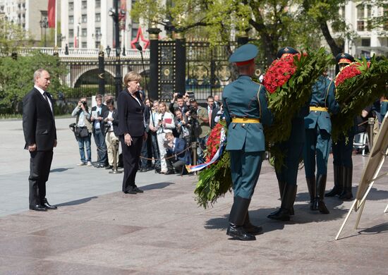 Vladimir Putin and German Chancellor Angela Merkel lay flowers at Tomb of the Unknown Soldier