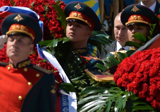 Vladimir Putin and German Chancellor Angela Merkel lay flowers at Tomb of the Unknown Soldier