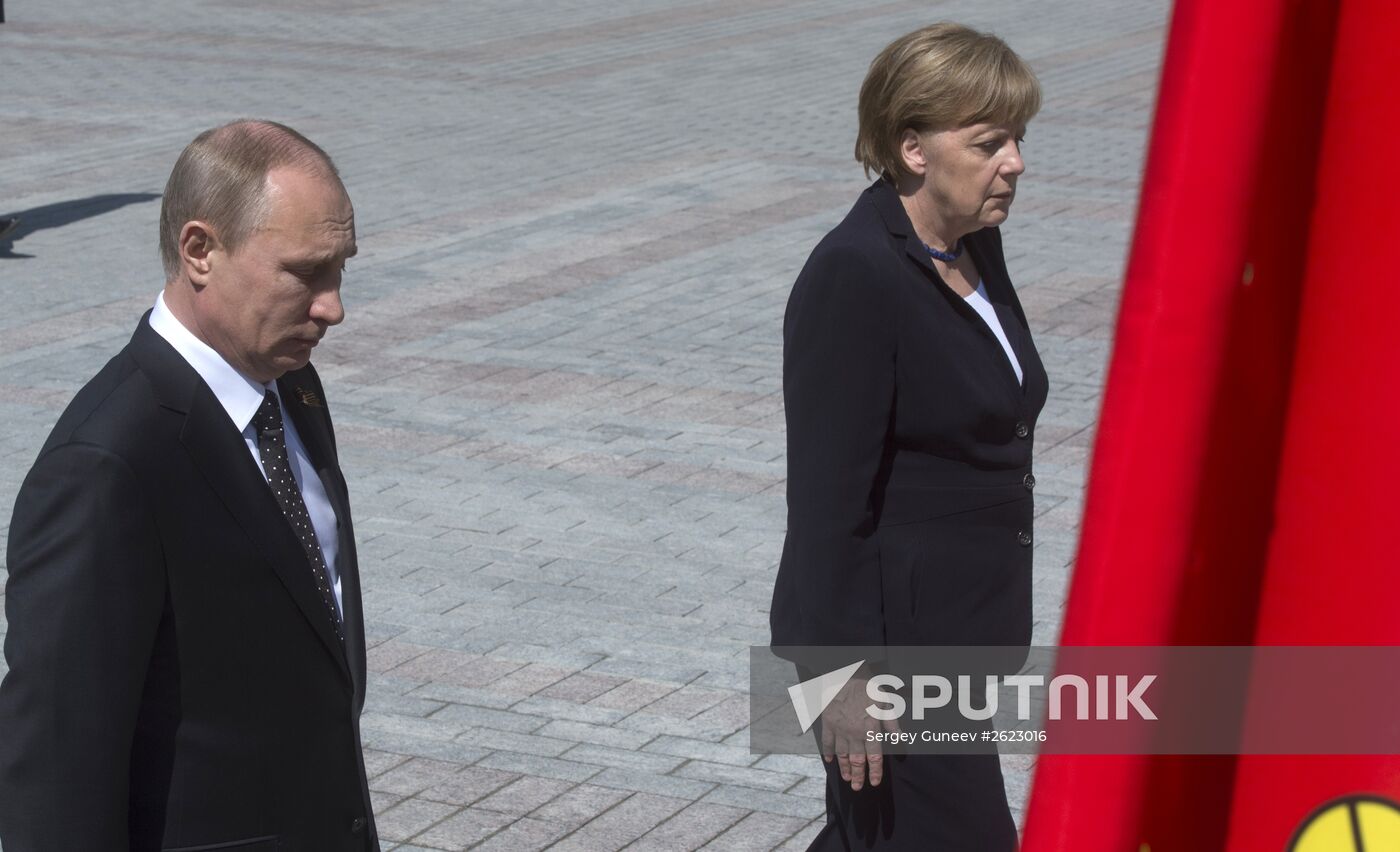 Vladimir Putin and German Chancellor Angela Merkel lay flowers at Tomb of the Unknown Soldier