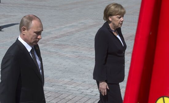 Vladimir Putin and German Chancellor Angela Merkel lay flowers at Tomb of the Unknown Soldier
