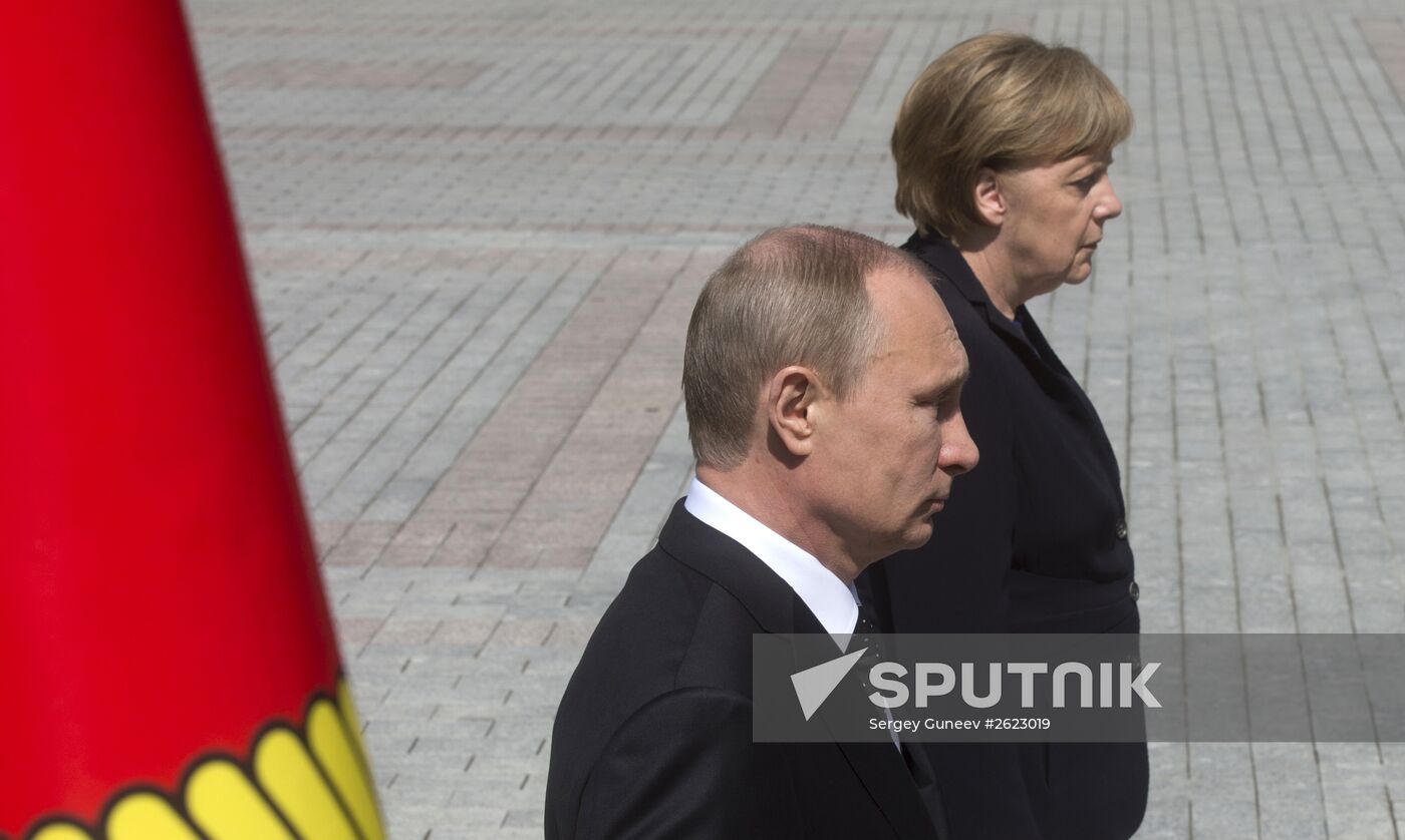 Vladimir Putin and German Chancellor Angela Merkel lay flowers at Tomb of the Unknown Soldier