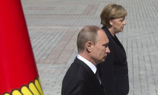 Vladimir Putin and German Chancellor Angela Merkel lay flowers at Tomb of the Unknown Soldier