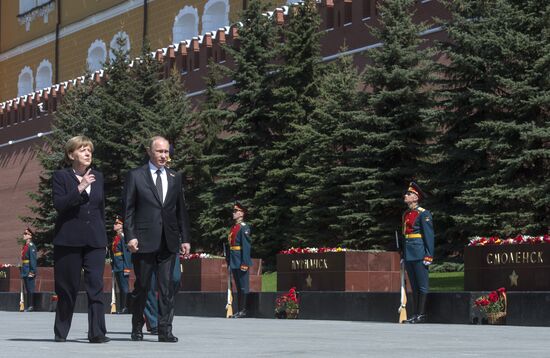 Vladimir Putin and German Chancellor Angela Merkel lay flowers at Tomb of the Unknown Soldier