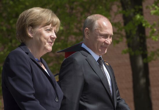 Vladimir Putin and German Chancellor Angela Merkel lay flowers at Tomb of the Unknown Soldier
