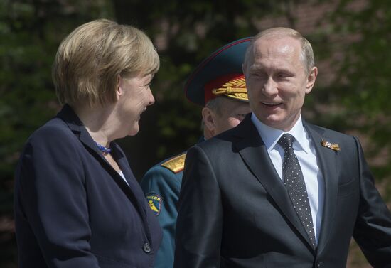 Vladimir Putin and German Chancellor Angela Merkel lay flowers at Tomb of the Unknown Soldier