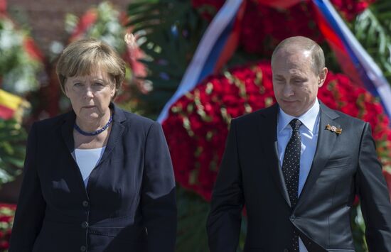 Vladimir Putin and German Chancellor Angela Merkel lay flowers at Tomb of the Unknown Soldier